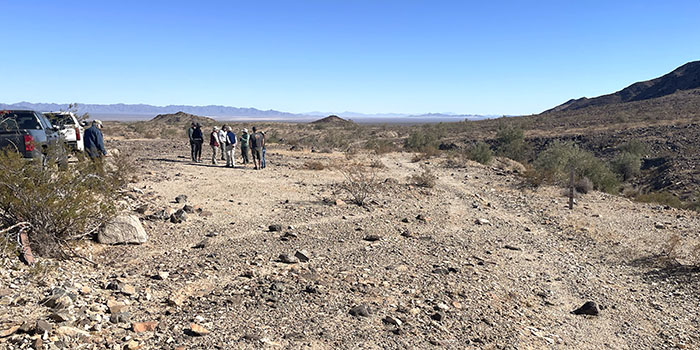 Site stewards visit vehicle tracks over an ancient trail in the desert